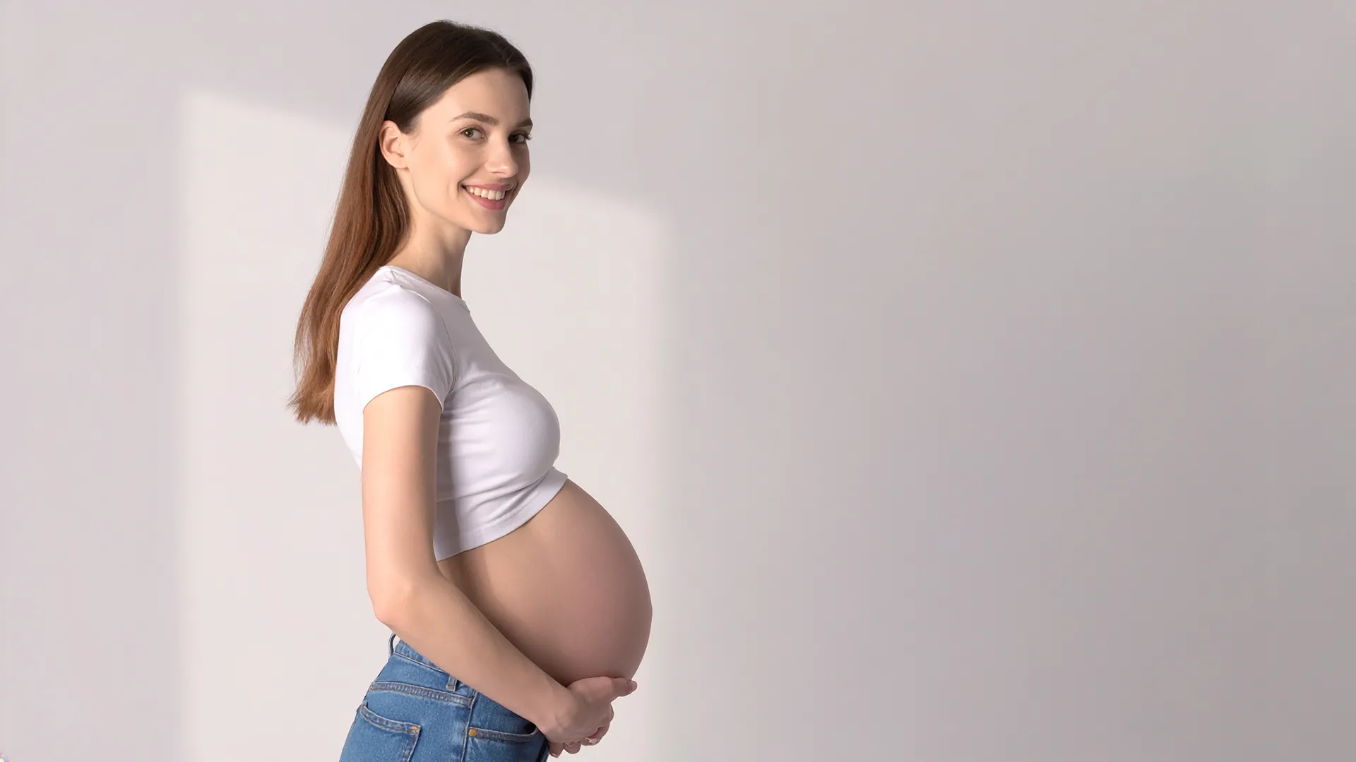 Grūtniece, kas sāniski tur savu augošo vēderu